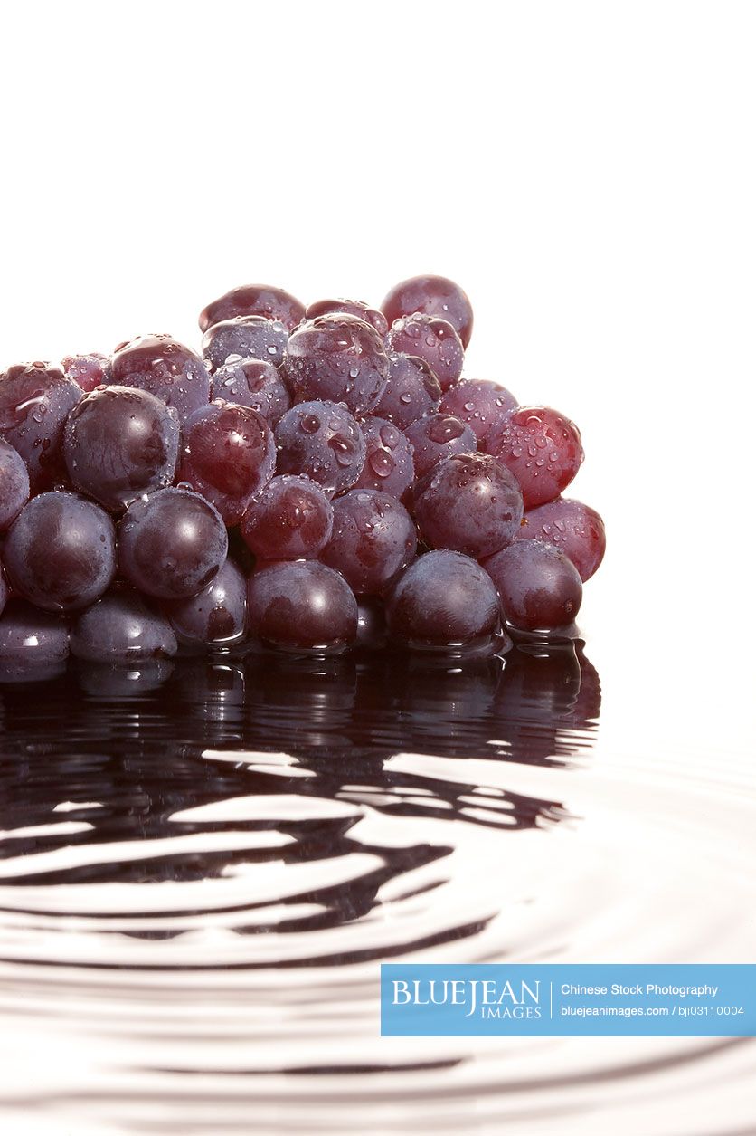 Close-up of a bunch of red grapes in rippling water