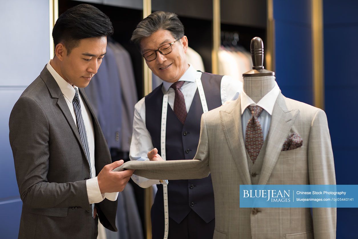 Chinese fashion designer showing customer business suit