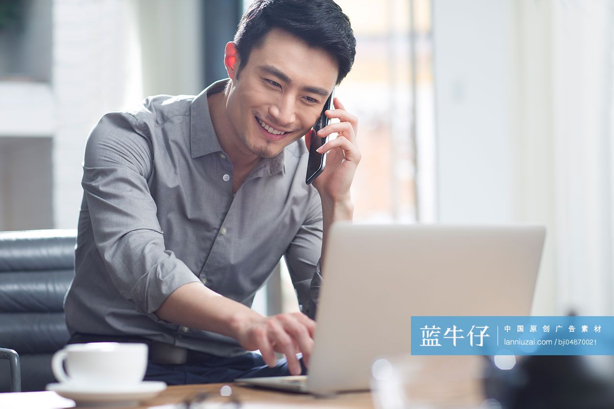 年轻商务男子在办公室打电话