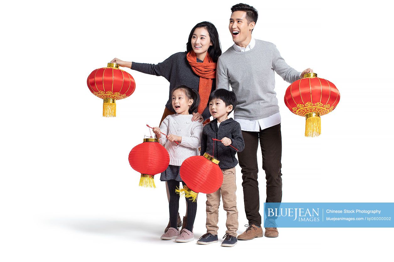 Happy young Chinese family holding lanterns