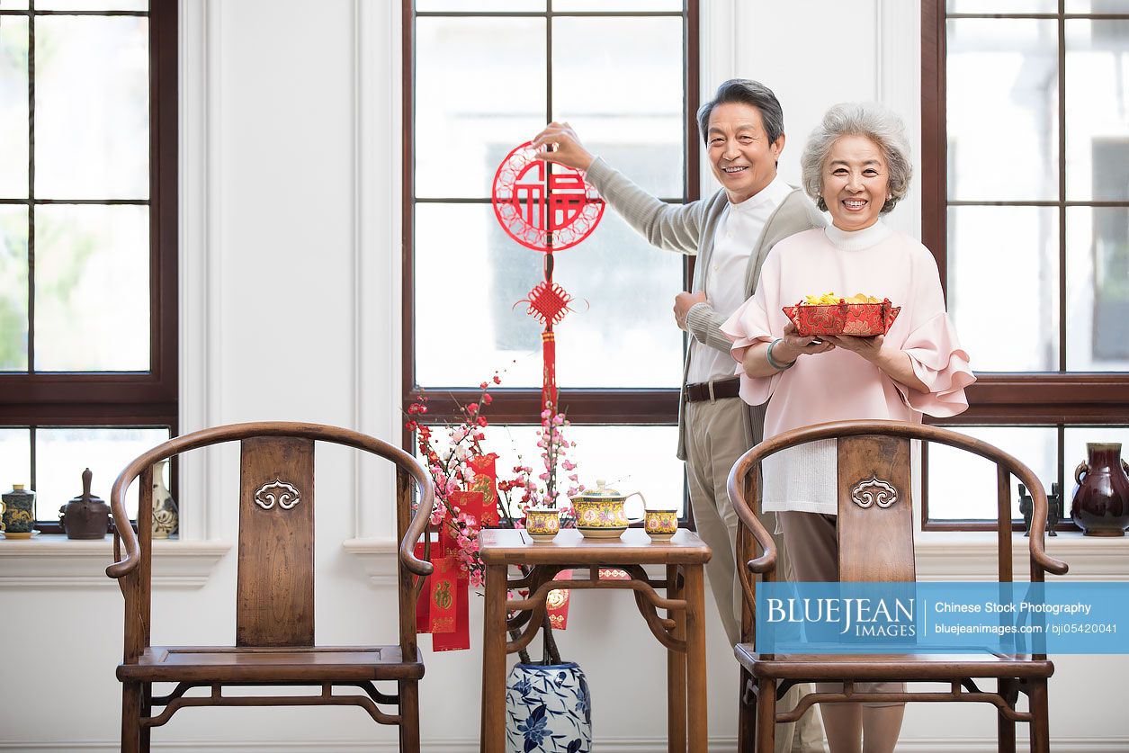 Senior couple decorating their house for Chinese New Year