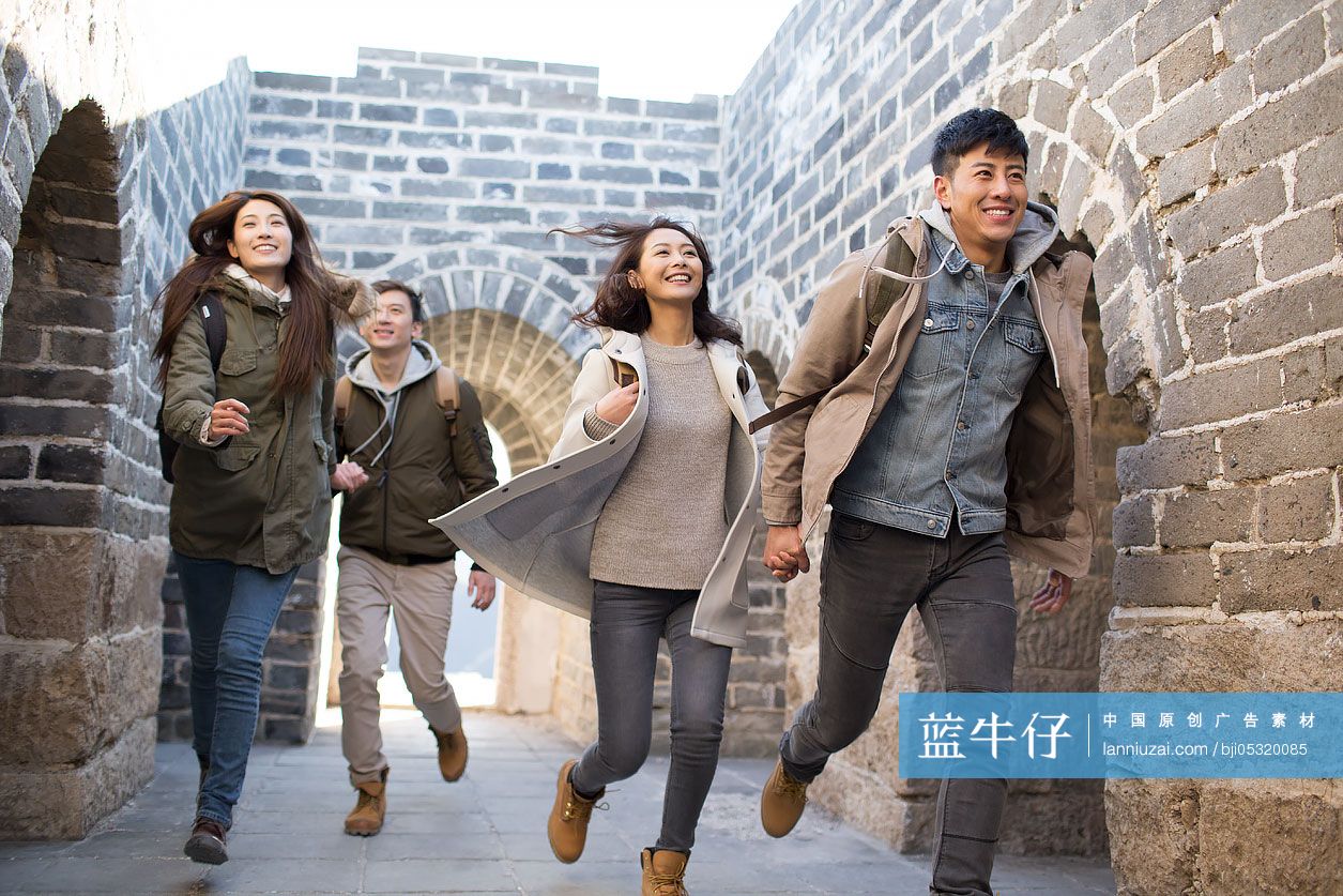 Happy young Chinese friends enjoying winter outing on the Great Wall