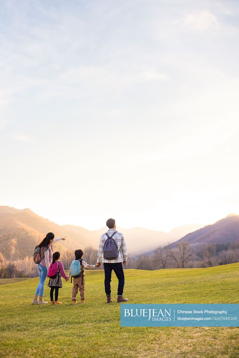 Cheerful young Chinese family enjoying the beautiful natural scenery