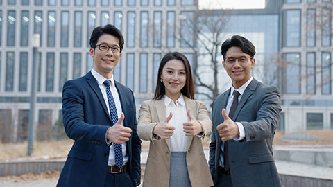 Confident Chinese business people doing thumbs-up