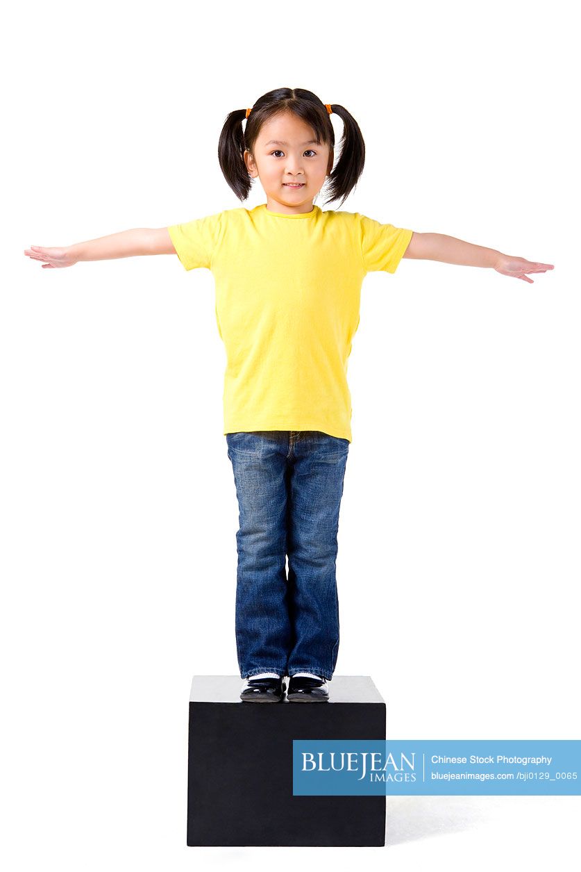 Little Chinese girl stands on some blocks with her arms stretched out-High-res  stock photo for download