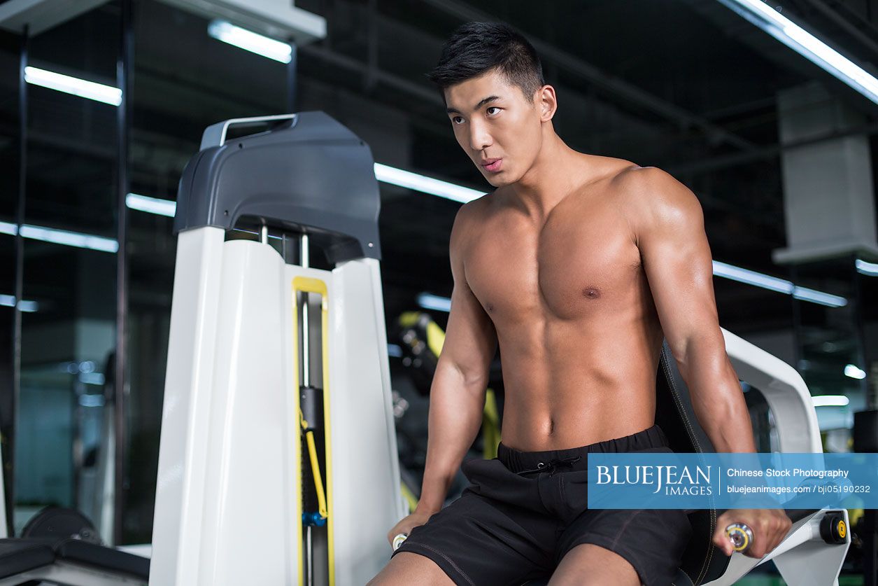 Young Chinese man exercising at gym