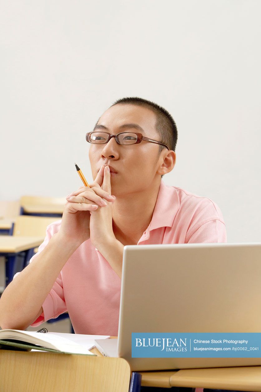 Chinese student making notes in a book