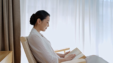 Elegant young Chinese woman reading book at home,4K