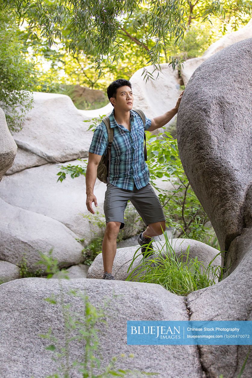 Young Chinese man hiking outdoors