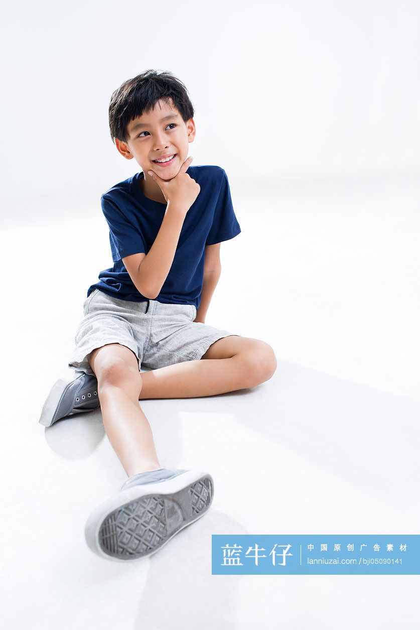 可爱的小男孩坐在地上想象
