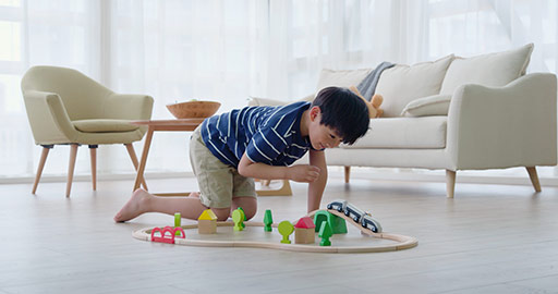 Happy little Chinese boy playing with toy train on floor,4K