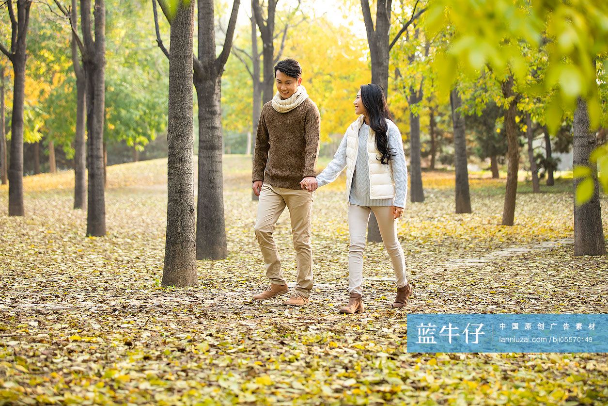 快乐的年轻情侣在树林散步