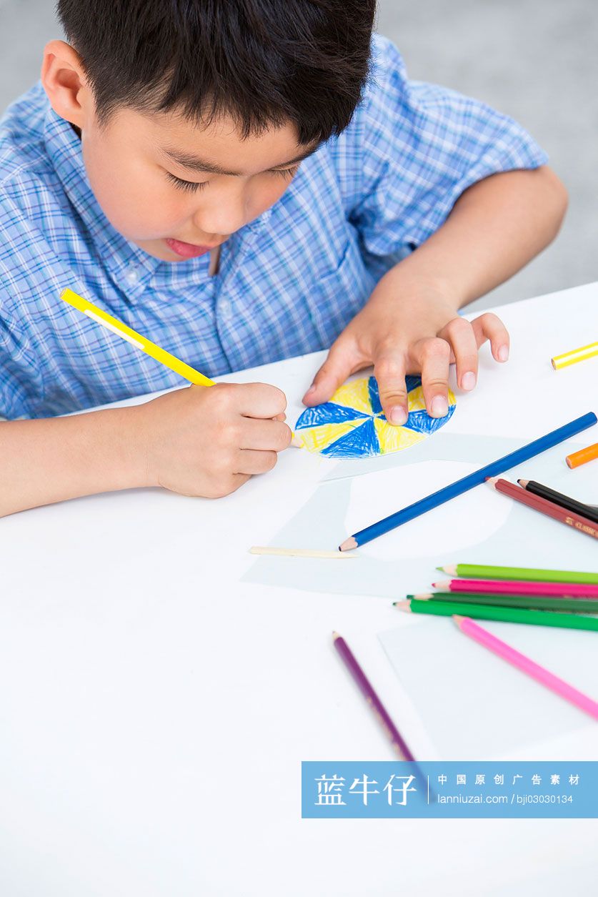 小男孩在做纸玩具