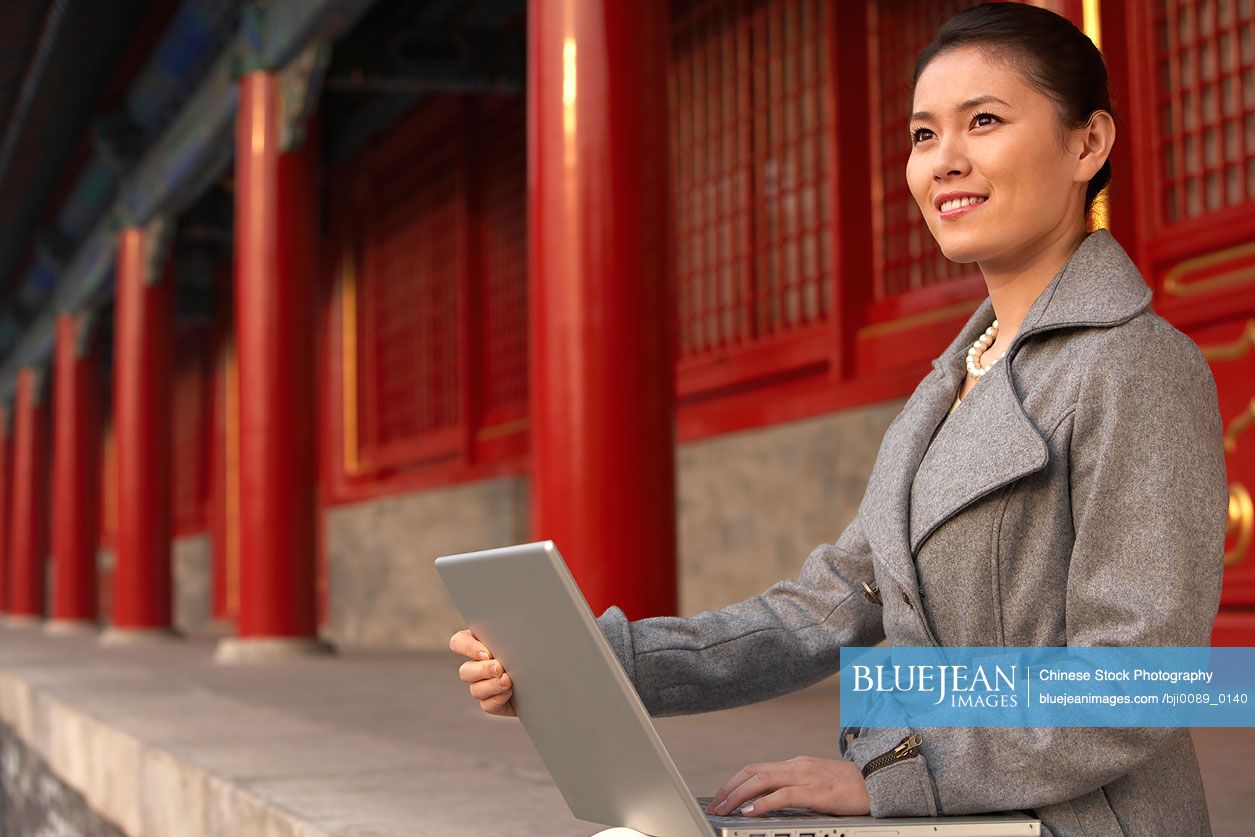 Chinese Businesswoman Using Laptop At The Forbidden City