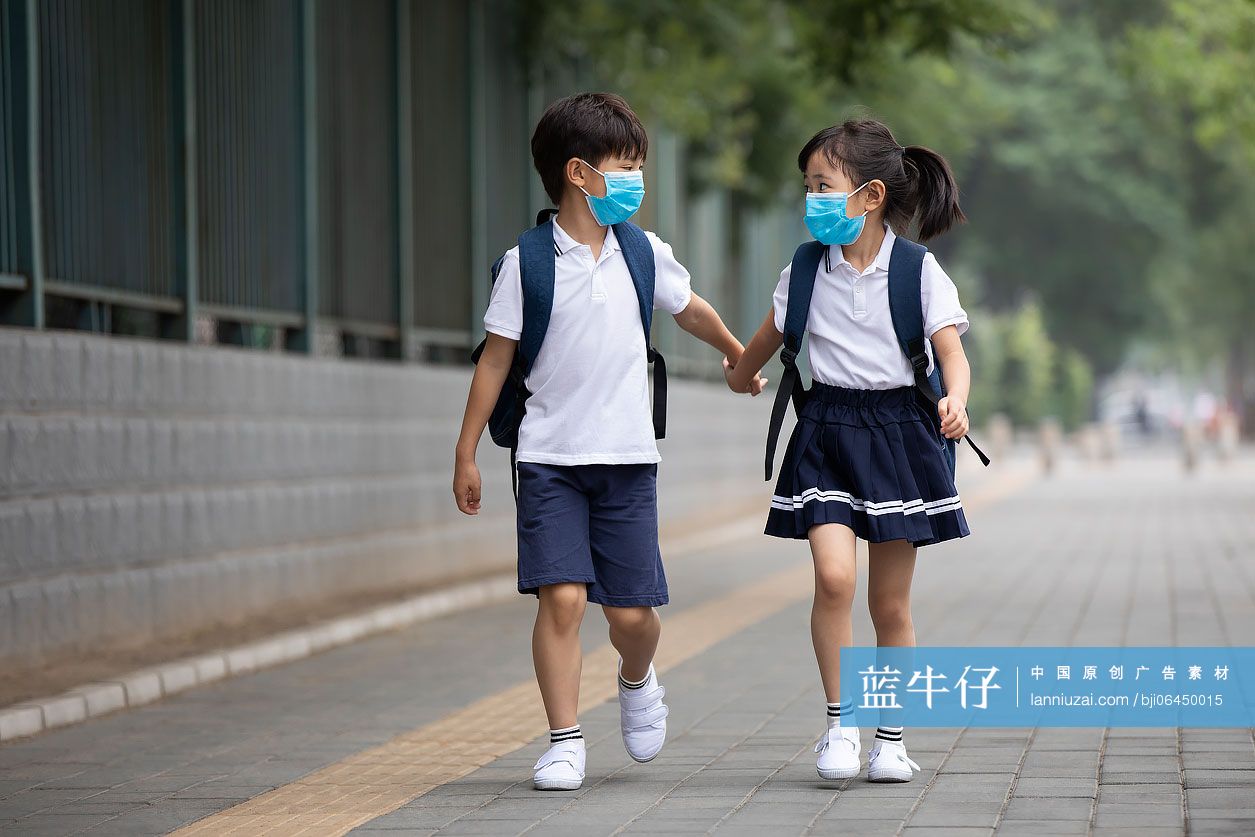 两个小学生戴着口罩去上学