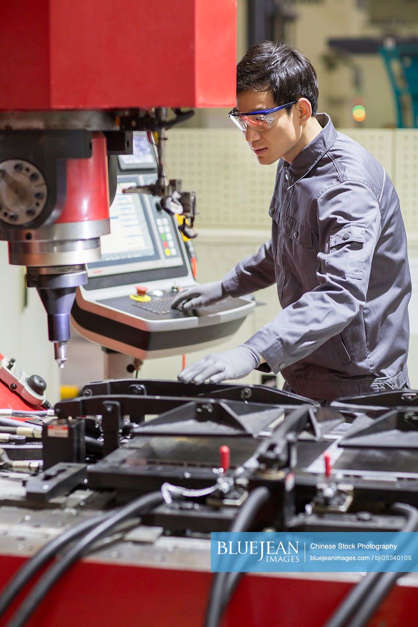 Young Chinese engineer working in the factory