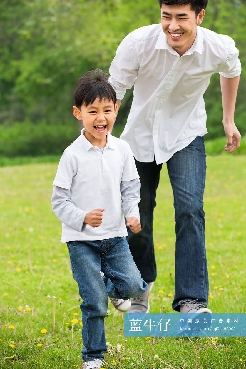 快乐的父子在草地上追赶嬉戏
