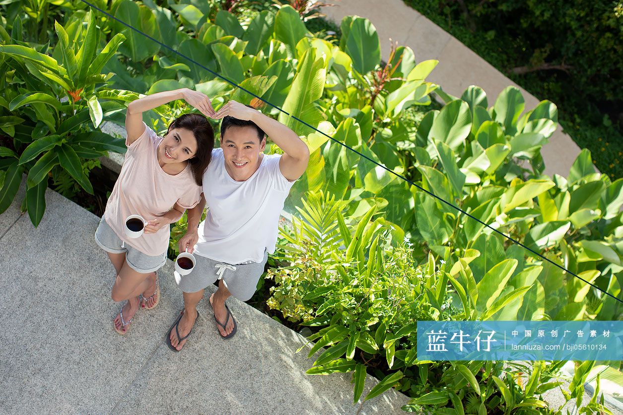 快乐的年轻夫妇在阳台喝咖啡