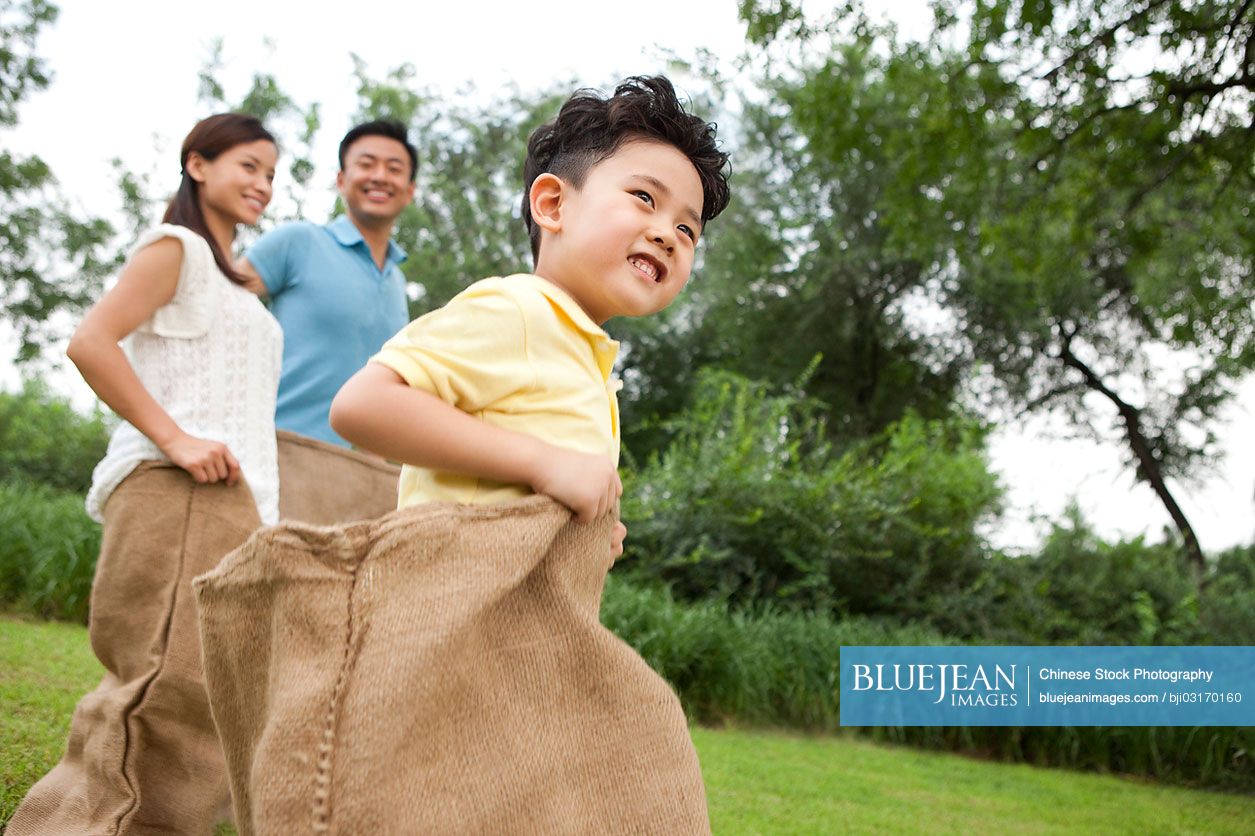 Cheerful Chinese family playing sack race