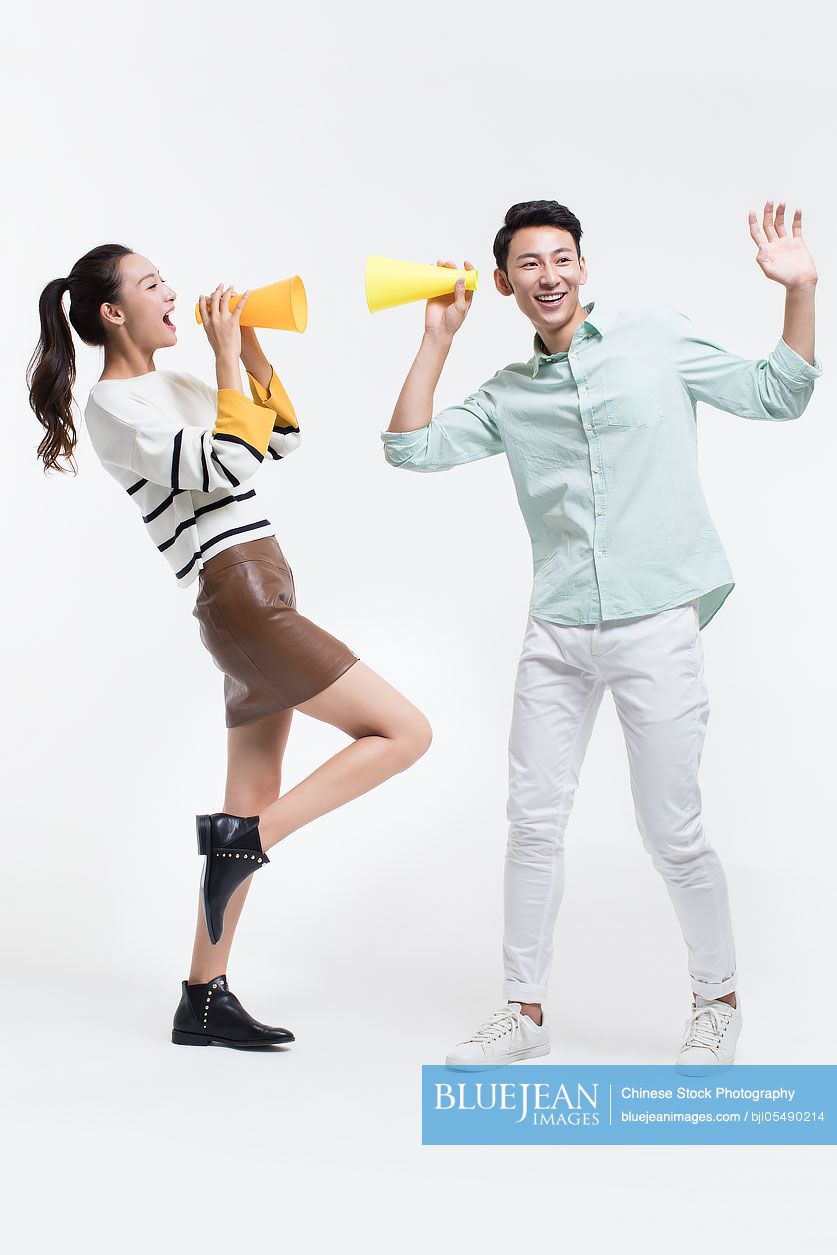 Young Chinese couple shouting through megaphones