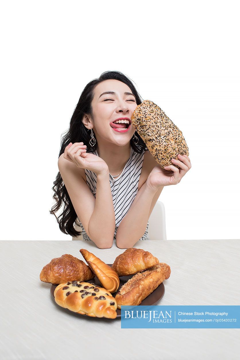 Fashionable young Chinese woman eating bread