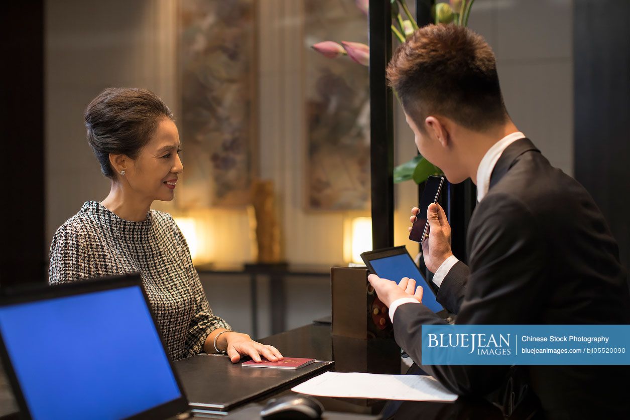 Elegant Chinese woman checking into hotel