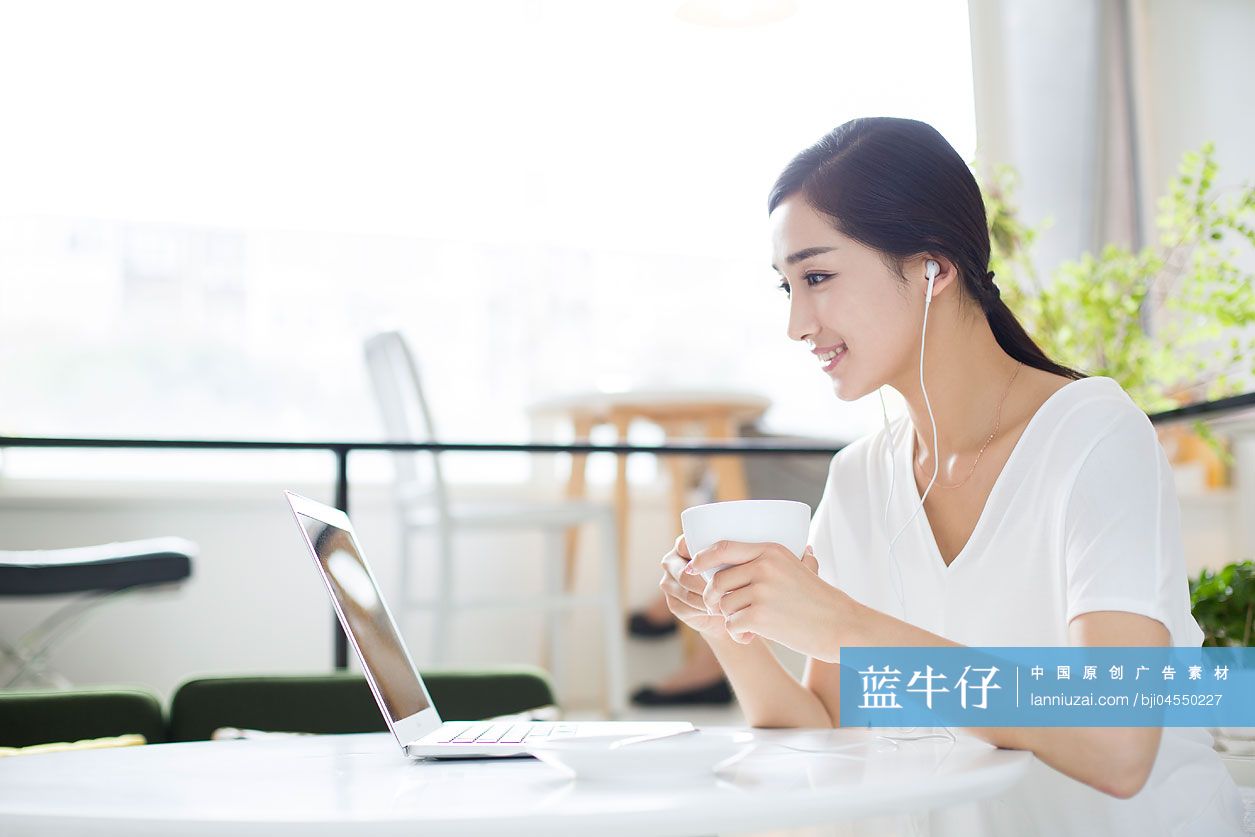 快乐的年轻女子在咖啡店听音乐