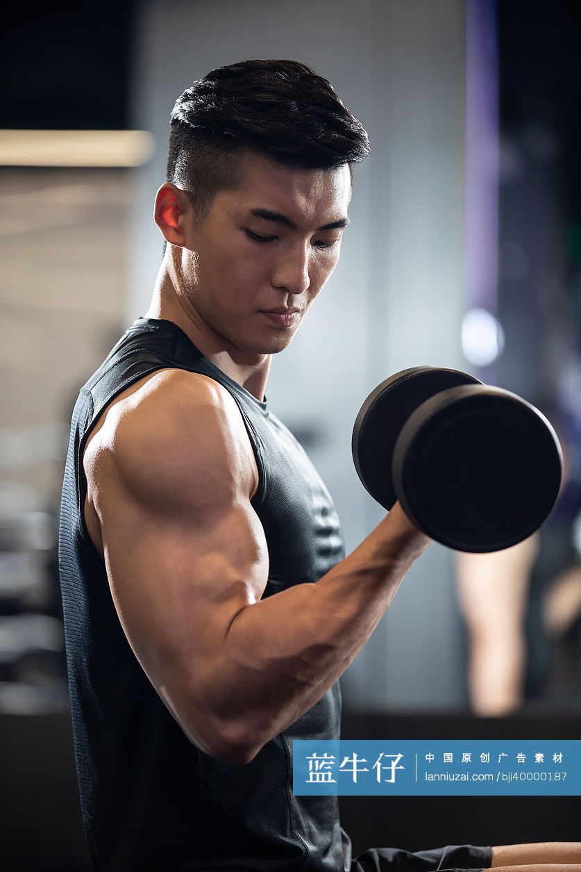年轻男士在健身房举哑铃