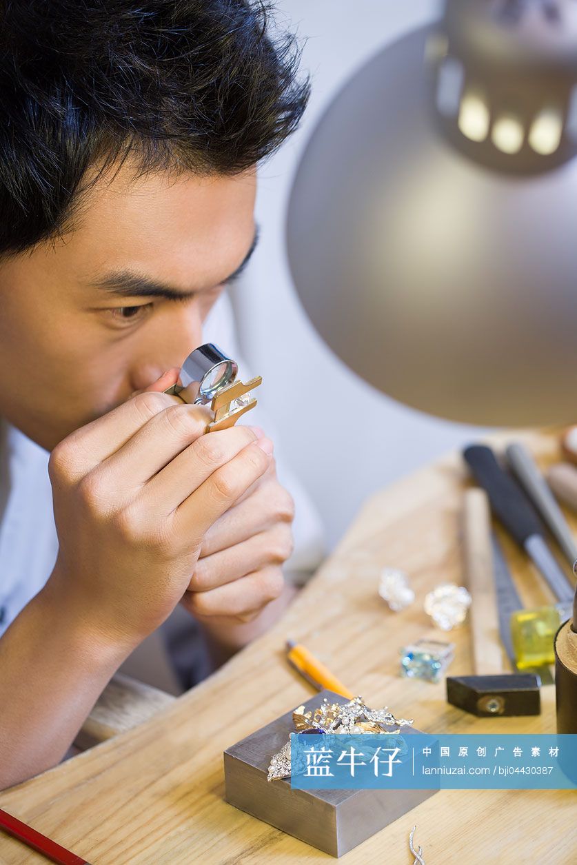 珠宝设计师用微型放大镜检查钻石