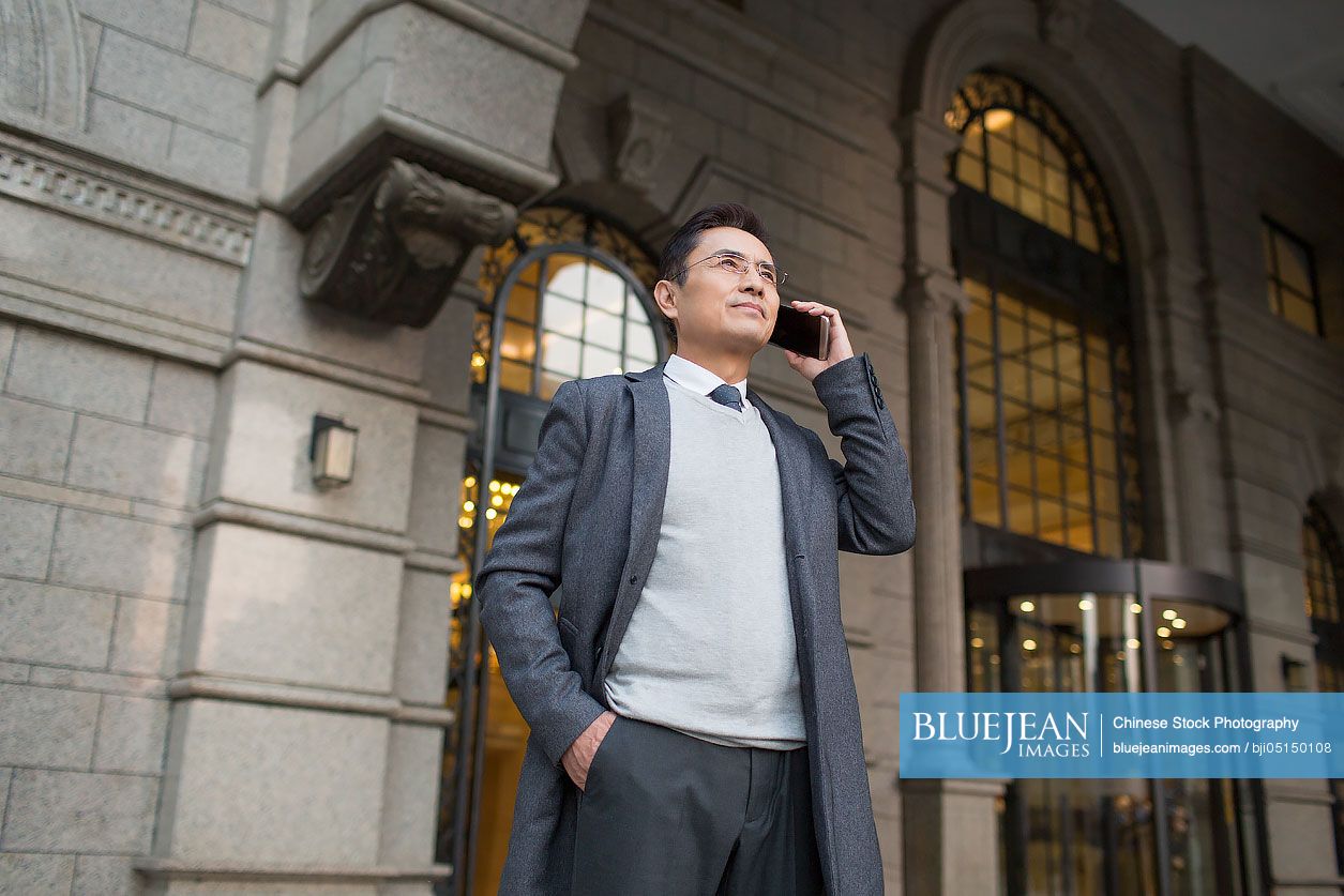Confident Chinese businessman talking on the phone