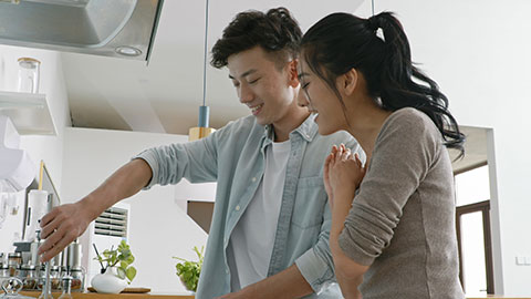 Happy young Chinese couple cooking in kitchen,4K