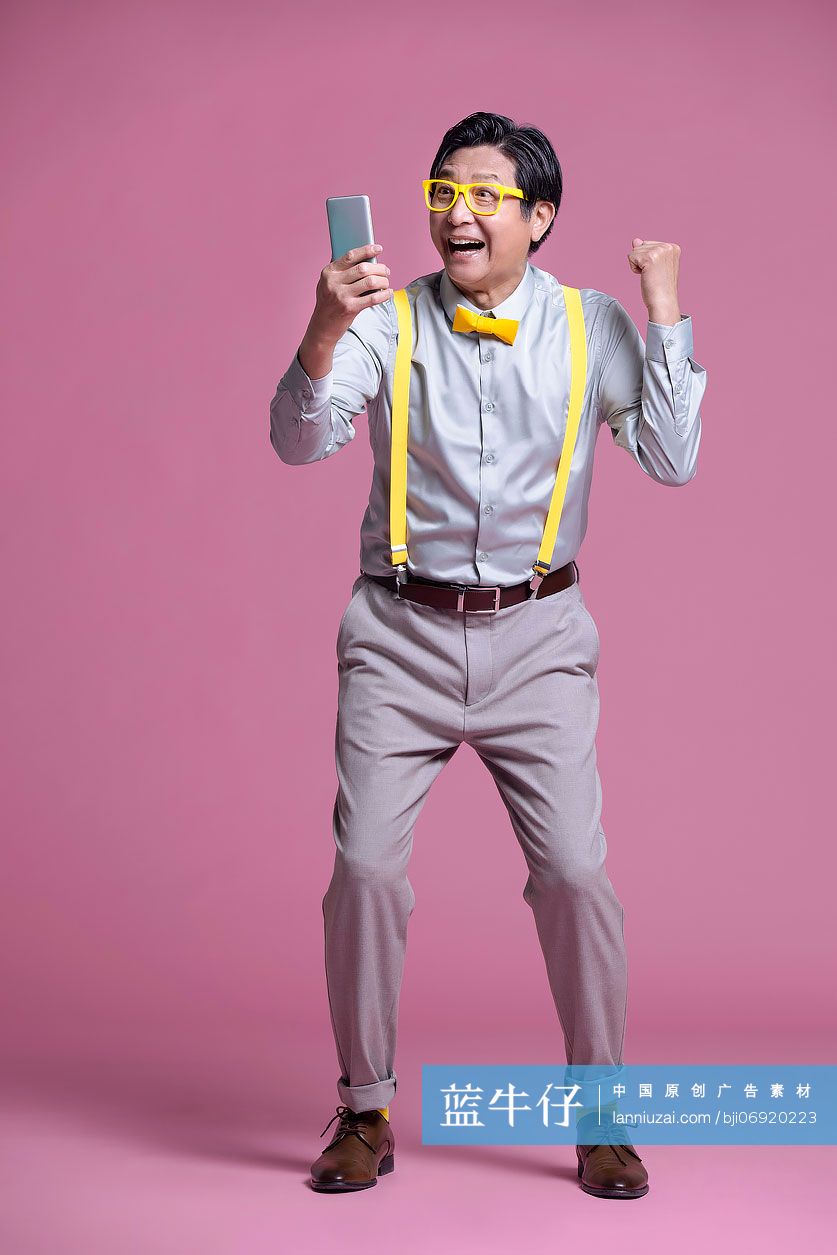 兴奋的老年男子看着手机