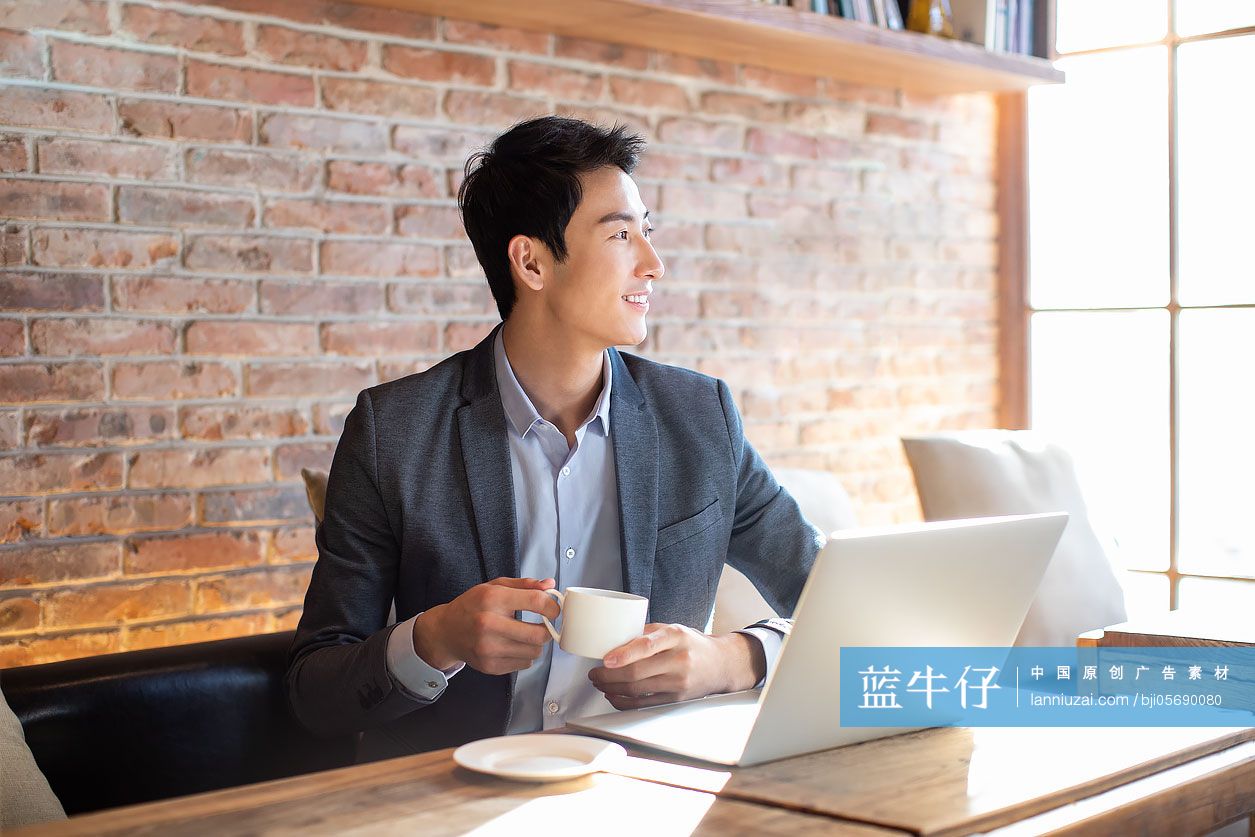 年轻商务男士在咖啡店喝咖啡