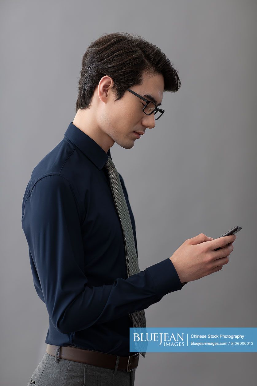 Young Chinese businessman using smartphone