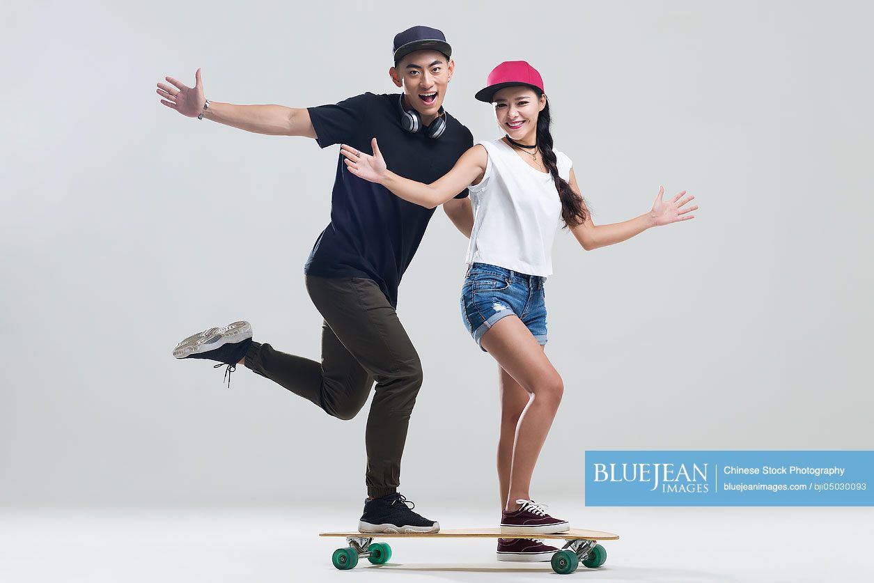 Cheerful young couple skateboarding