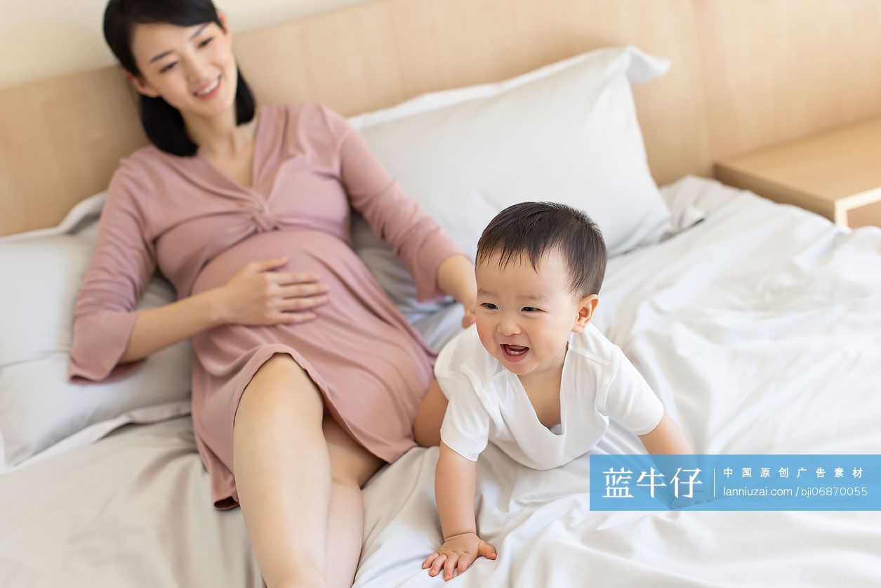 怀孕的妈妈在家陪宝宝玩耍