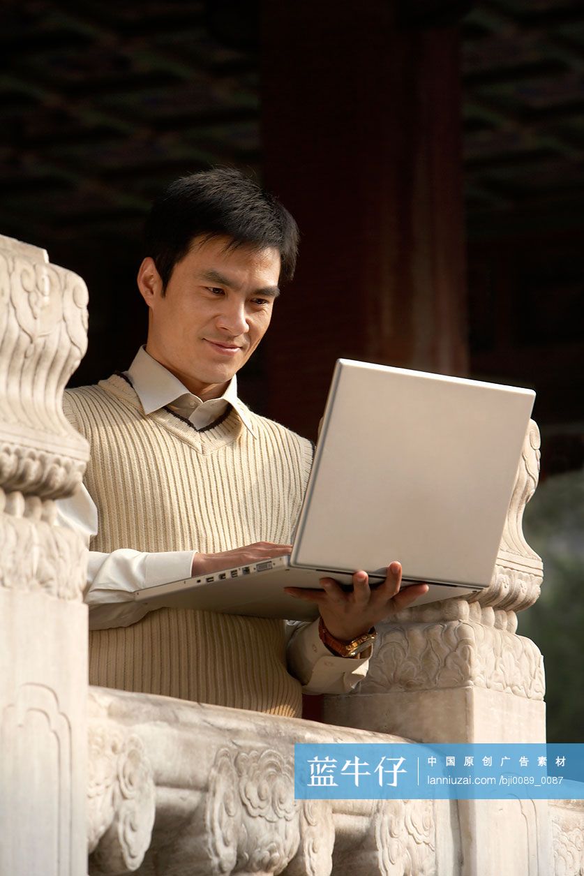 故宫里的商务男士使用笔记本电脑
