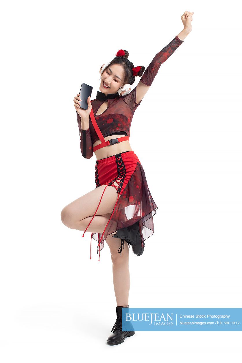 Cheerful young Chinese woman listening to music