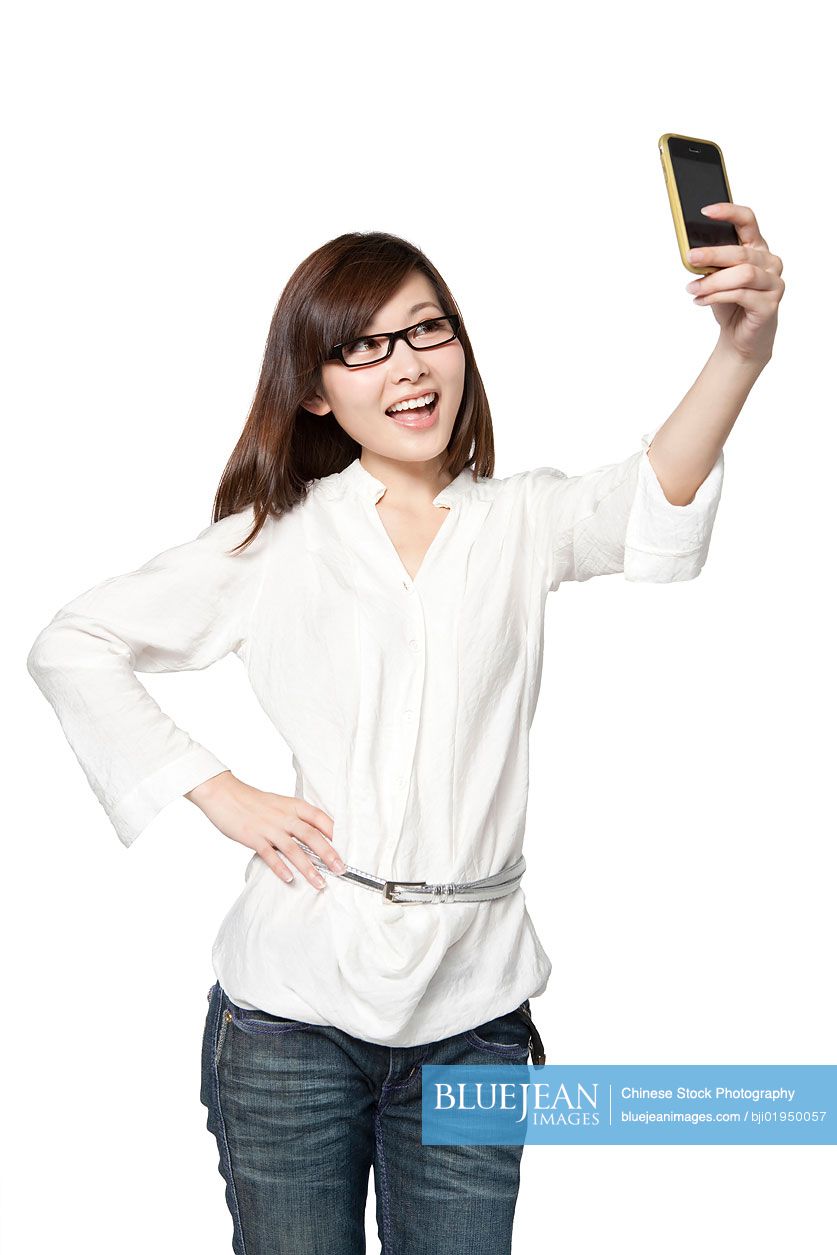 Portrait of young Chinese woman taking a photograph of herself