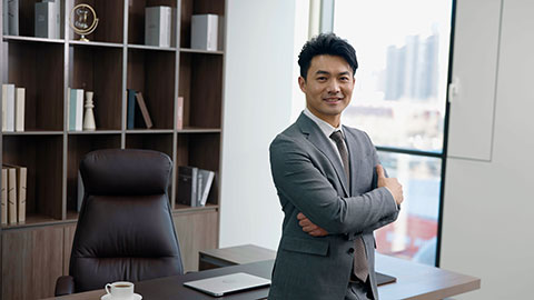 Successful Chinese businessman standing in office