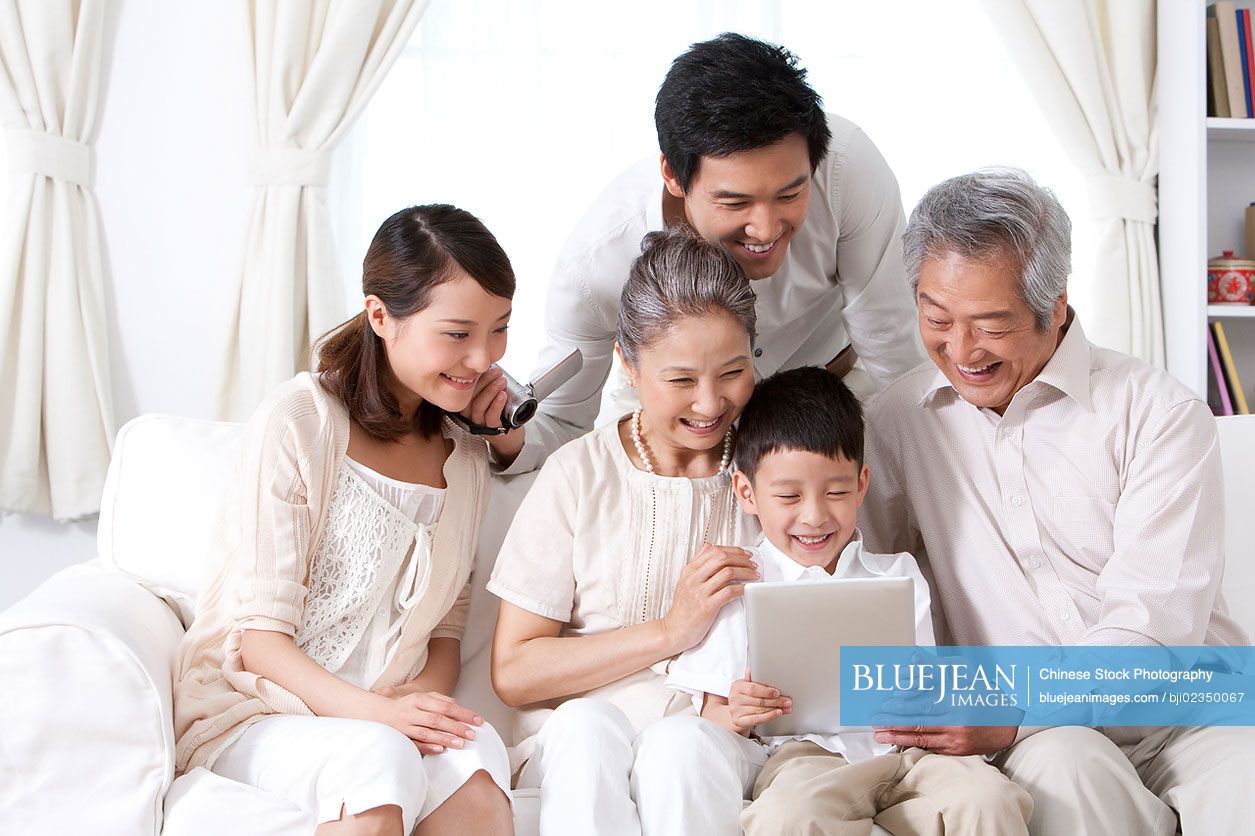 Happy Chinese family using an ipad together