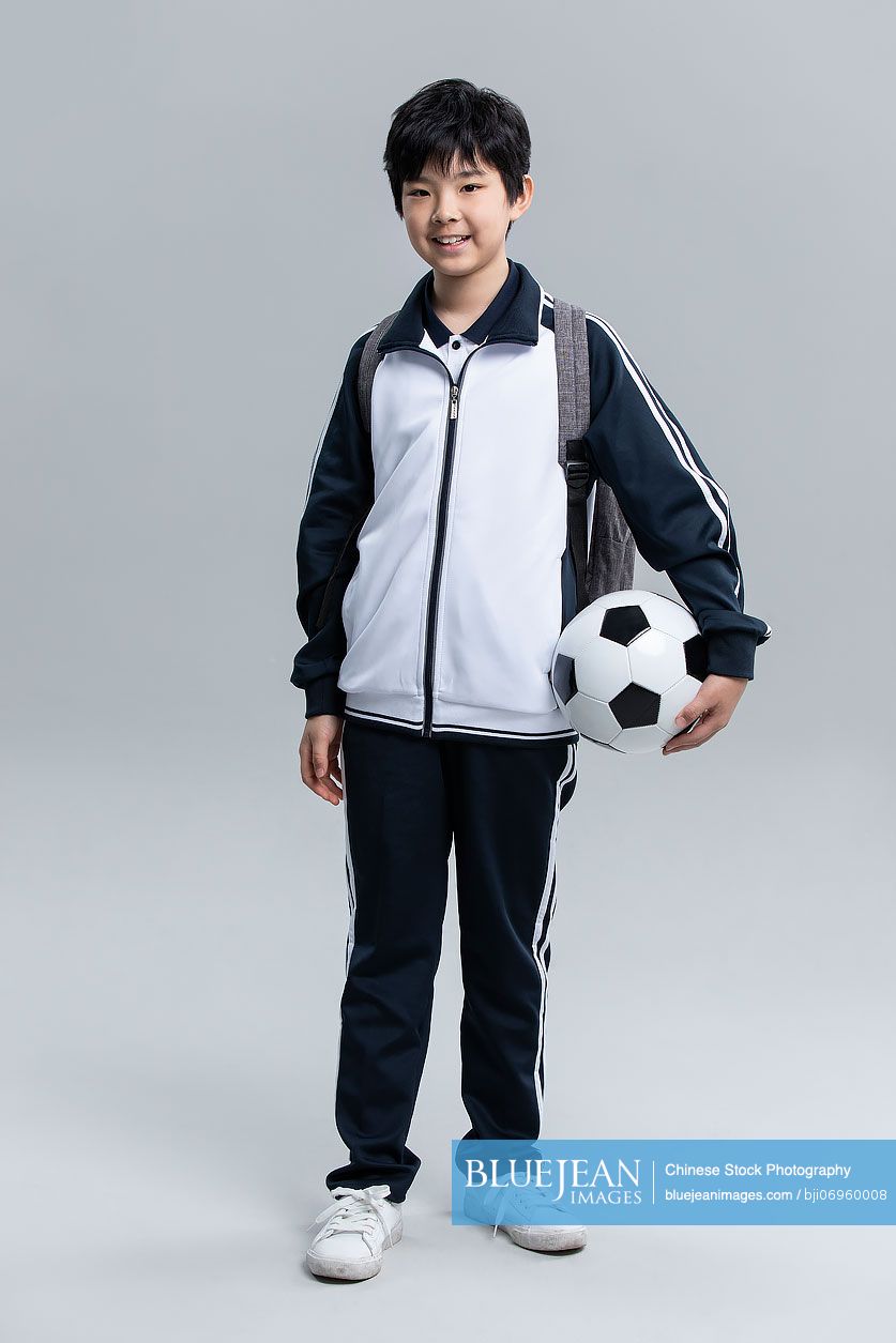 portrait-of-cheerful-chinese-student-with-football-high-res-stock-photo