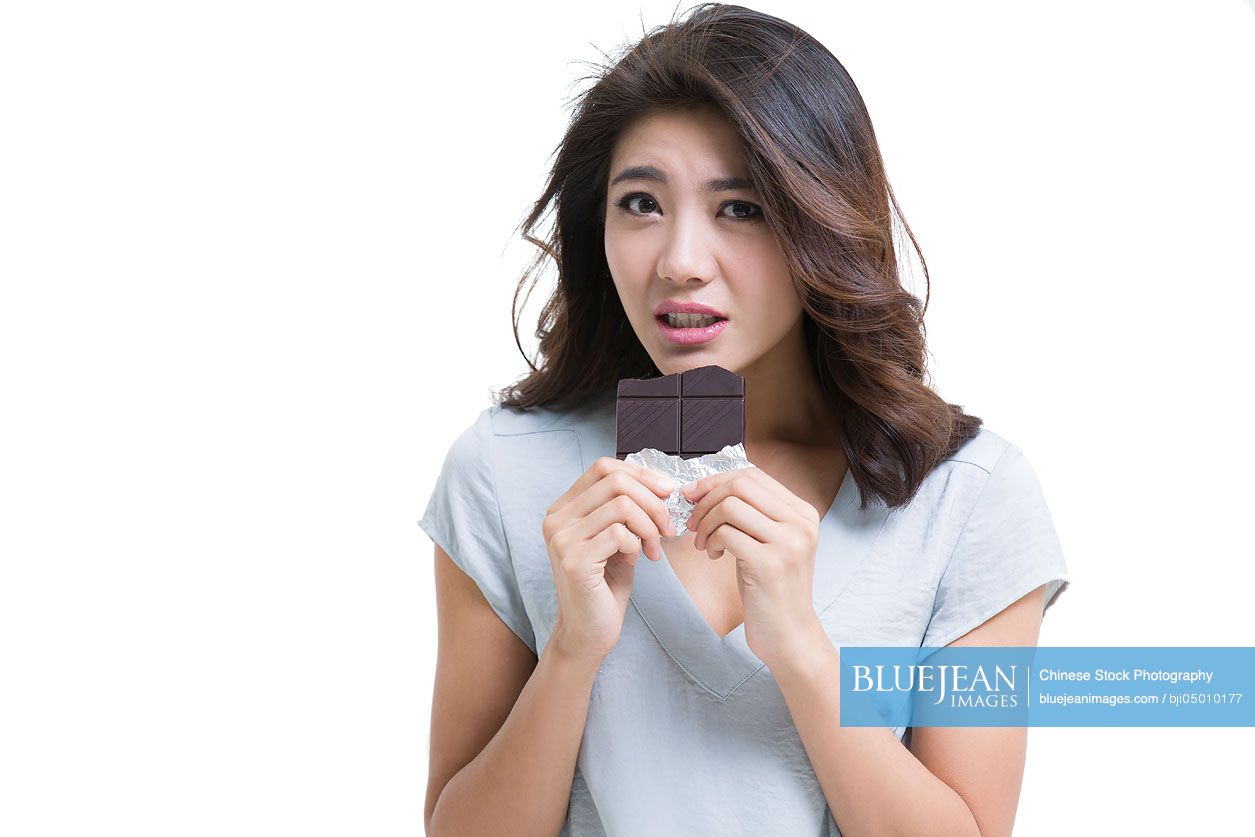 Young Chinese woman eating chocolate