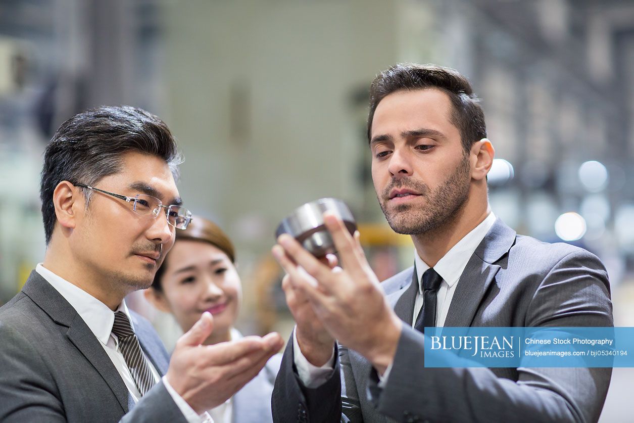 Business people checking machine parts in the factory