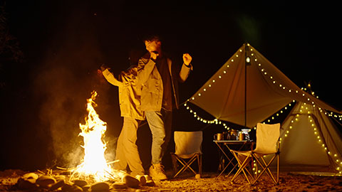 Happy young Chinese couple camping outdoors