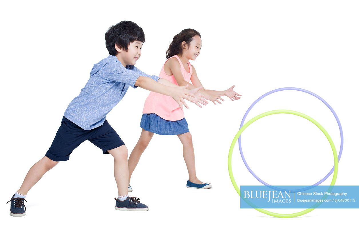 Happy Chinese children rolling plastic hoops