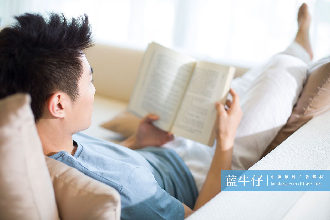 年轻男子在沙发上看书