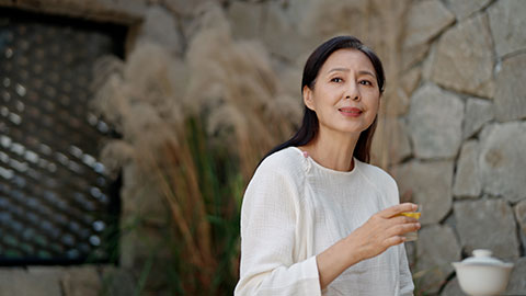 Elegant mature Chinese woman drinking tea in tea room,4K