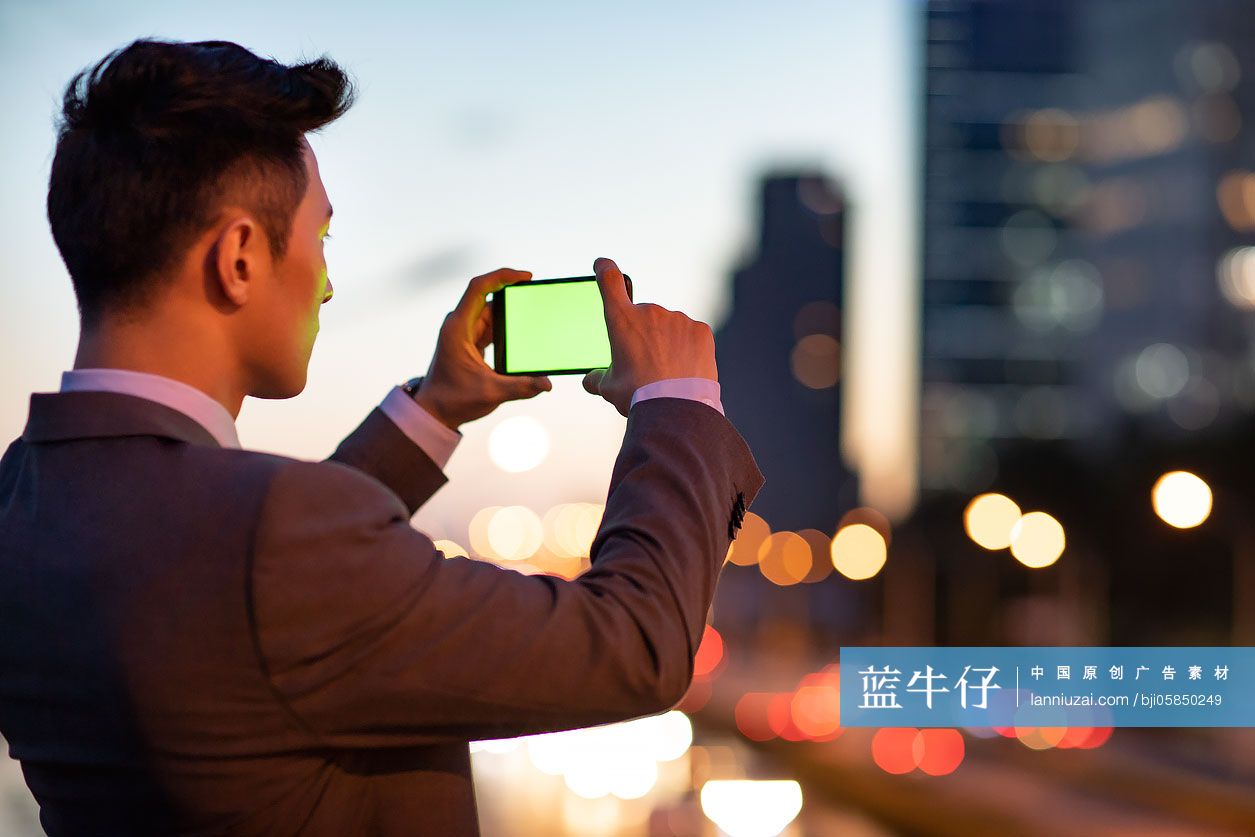 年轻商务男士用手机拍照