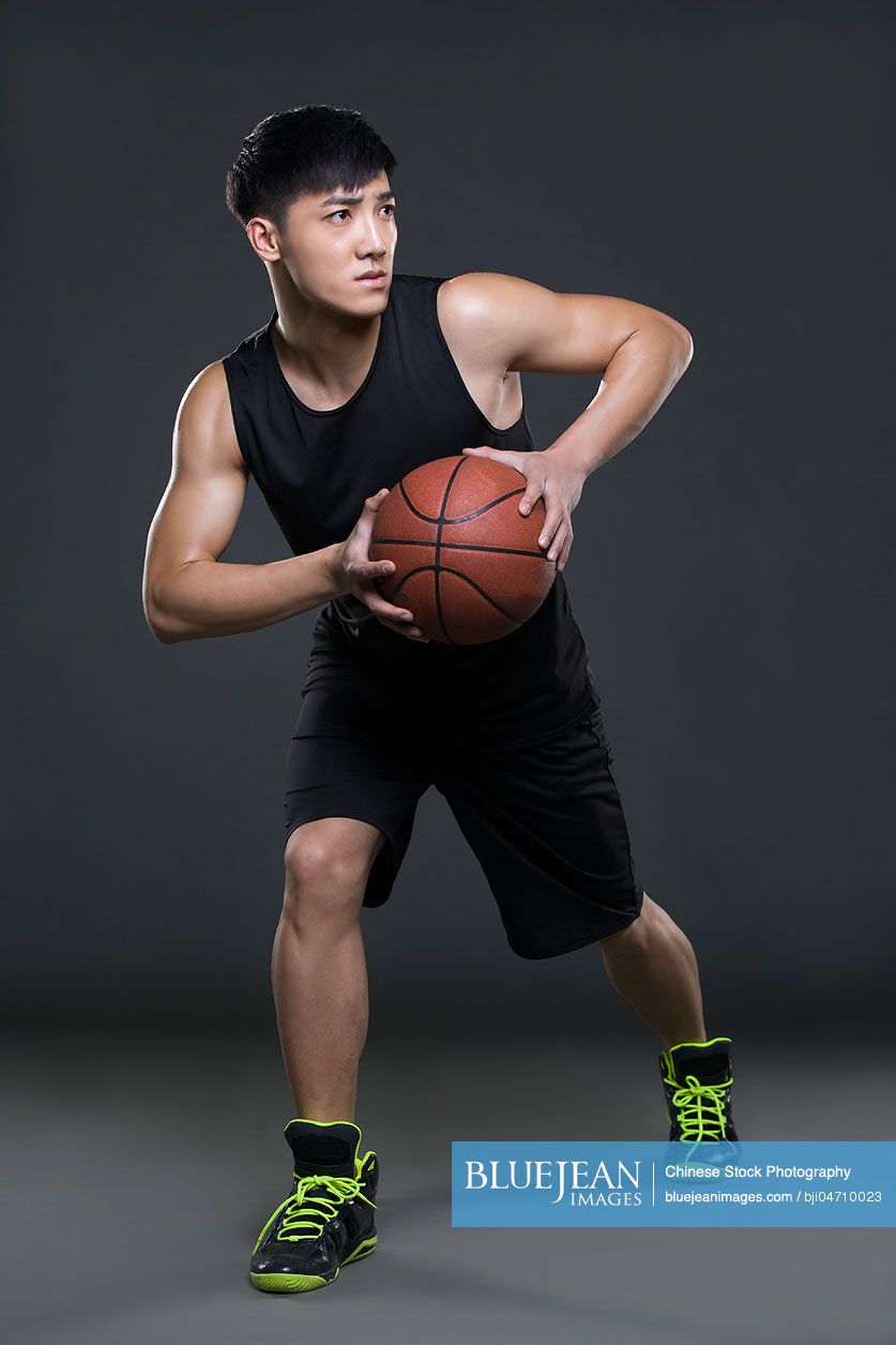 Young Chinese man playing basketball